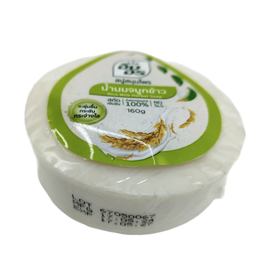 Round, white soap with a green label featuring rice grains and Thai text, identified as Parrot Botanicals' 160g Thai Rice Milk Herbal Soap (100% Natural, SLS-Free) for skin-brightening.